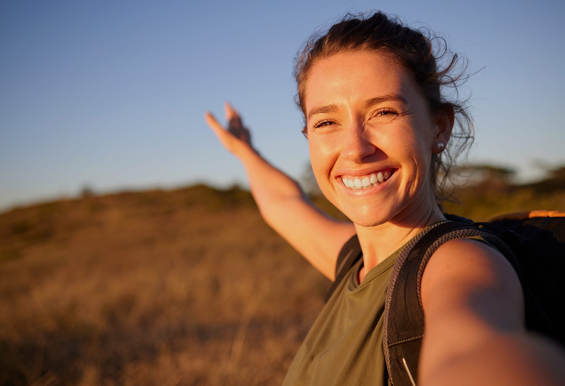 Smiling woman outdoors at golden hour